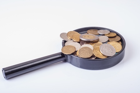 an image of coins lying on magnifying glassの写真素材