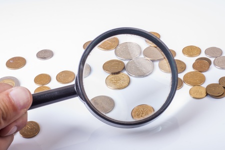 an image of coins lying on magnifying glassの写真素材