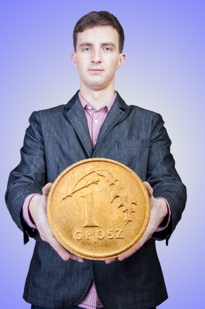 An image of young businessman holding big coin of moneyの写真素材