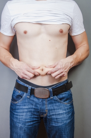An image of man hold his fat on stomachの写真素材