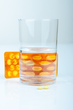 An image of headache pills and glass of waterの写真素材
