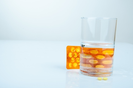 An image of headache pills and glass of waterの写真素材