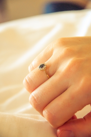 Gold engagement ring in womens handの写真素材