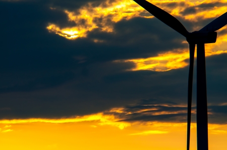 An image of wind turbines at sunset