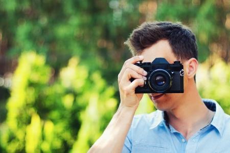 young photographer takes pictures with the old retro cameraの写真素材
