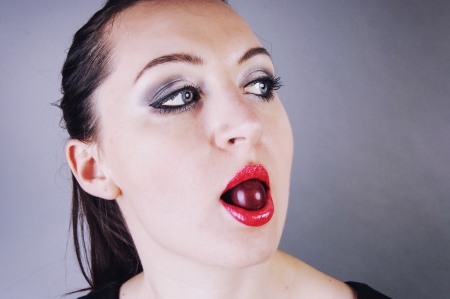 an image of girl eating cherryの写真素材