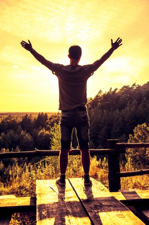 An image of man with open hands at the edge of woodsの写真素材