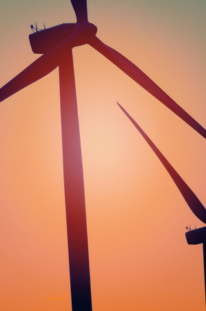 Wind turbine farm with rays of light at sunsetの写真素材
