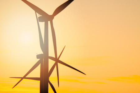 Wind turbine farm with rays of light at sunset