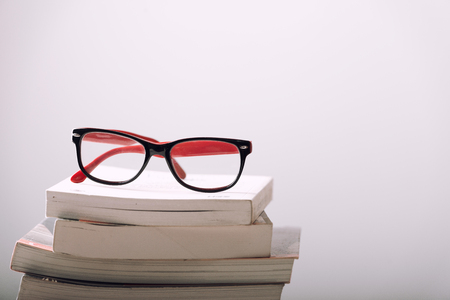 book and eyeglasses on wood background deskの写真素材