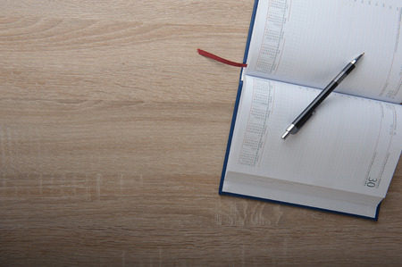 Notebook with pen on the wooden deskの写真素材