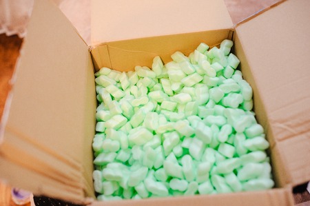 Large packaging box filled with many white polystyrene pelletsの写真素材