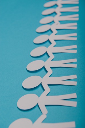 abstract paper people holding for hands on blue backgroundの写真素材