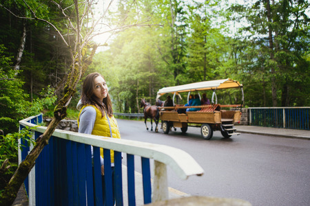 Woman walking over wooden bridge in summer timeの写真素材