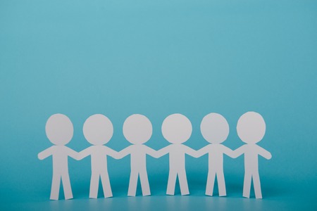 abstract paper people holding for hands on blue background