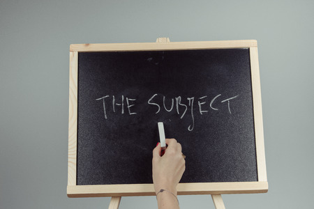 subject written in white chalk on a black chalkboard . gray backgroundの写真素材