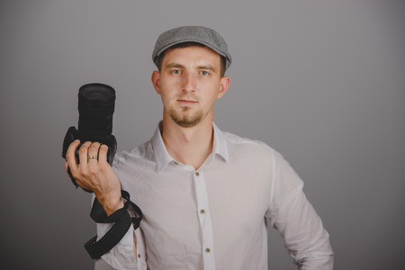 Young man using a professional camera in studioの写真素材