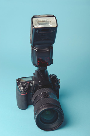 Professional modern DSLR camera against blue background