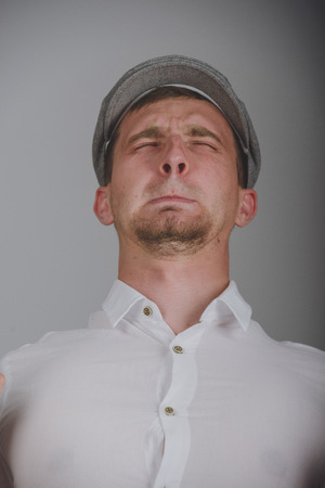 young man with a strong pain against gray backgroundの写真素材