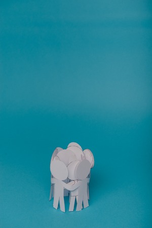 abstract paper people holding for hands on blue backgroundの写真素材