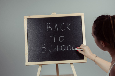 Back to school blackboard, chalkboard. Teacher writing back to school on black chalk boardの写真素材