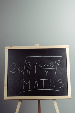 Math exercise written on the chalkboard. Gray backgroundの写真素材