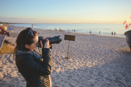professional woman photographer on the beach, summer timeの写真素材