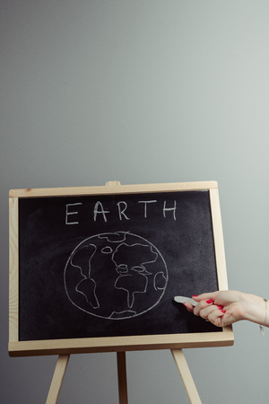earth written on blackboard with earth symbol, background, high resolution, gray backgroundの写真素材