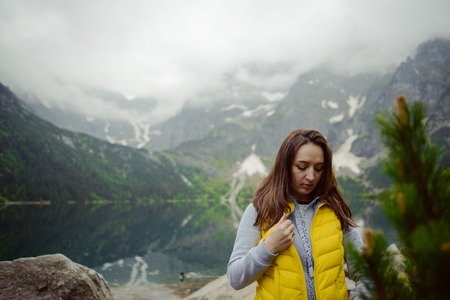 woman relaxing on the lake and mountains sunny landscape.の写真素材
