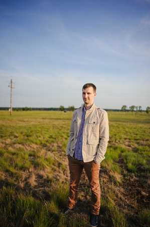 man on meadow under blue skies at spring timeの写真素材