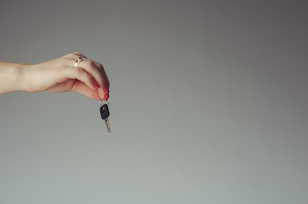 Keys from the car hold by female handの写真素材