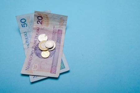 Polish zloty in notes and coins on blue backgroundの写真素材