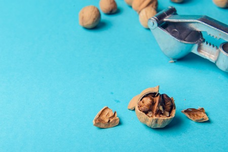 Walnuts with nutcracker, walnuts close-up, walnuts on a blue backgroundの写真素材
