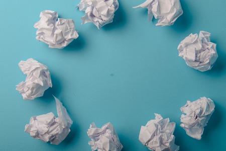 crumpled paper ball isolated on a blue backgroundの写真素材