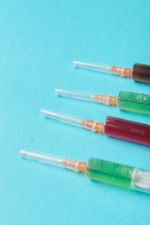 syringe on blue background. Injections. Food adittiveの写真素材