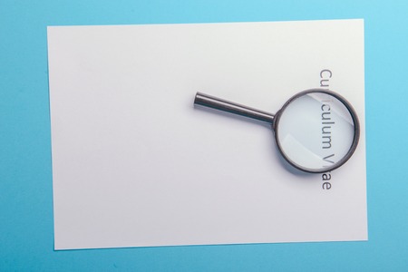 Curriculum vitae written on an blank white paper on blue backgroundの写真素材