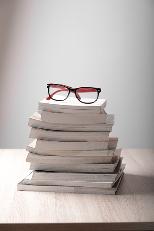 book and eyeglasses on wood background deskのeditorial素材