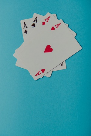 A winning poker hand of four aces playing cards on blue backgroundの写真素材