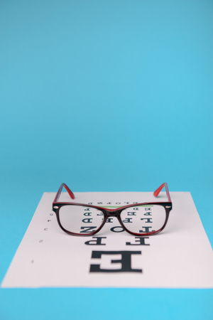 close up view of glasses lying on snellen test chartの写真素材