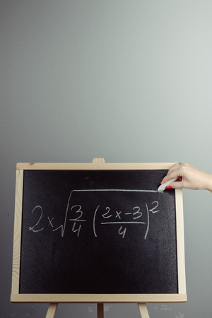 Math exercise written on the chalkboard. Gray backgroundの写真素材