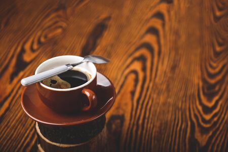 Cup of hot espresso coffee and coffee crop on wood boardの写真素材
