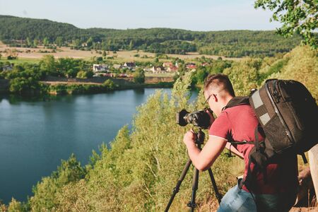 photographer taking photo of wildlife, man with camera setting up a tripod