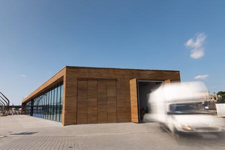 White delivery truck leave warehouse, long exposure with motion blur effect