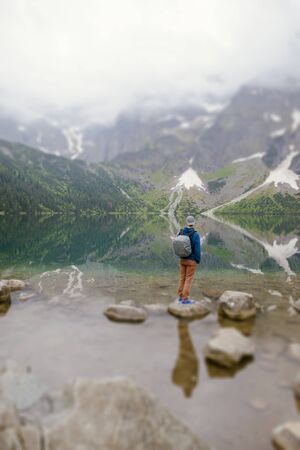 man relaxing on the lake and mountains sunny landscape.の写真素材