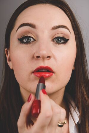 Professional Make-up. Lipgloss. Red Lipstick applyingの写真素材