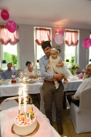 Baby girl 1 year old eating birthday cake in room. Birthday party. Childhood.の写真素材