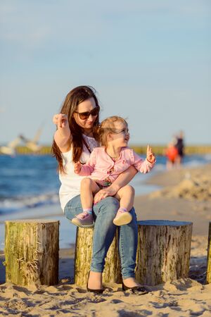 Mother and little daughter walking on the beach.の写真素材