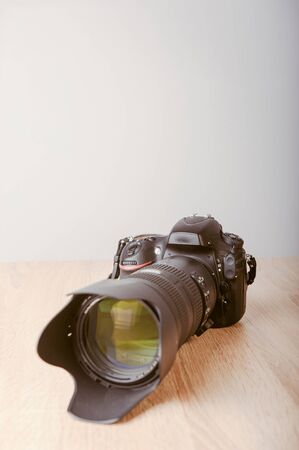 Digital photo camera on wooden desk table