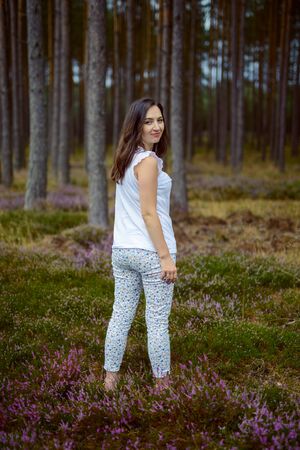 a photo of woman in the forest where the purple heather blooms. copy space. authentic imageの写真素材