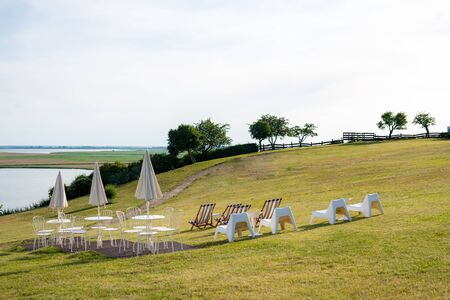 Empty beach chair on meadow on summer time. Sunlight and sea in the background. Coast lineの写真素材